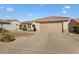 Tan house with a two-car garage and desert landscaping at 15920 W Summerwalk Dr, Surprise, AZ 85374