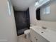 Modern bathroom with dark tile shower and white vanity at 1633 N 62Nd Ave, Phoenix, AZ 85035