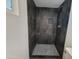 Large walk-in shower with dark tile and pebble floor at 1633 N 62Nd Ave, Phoenix, AZ 85035