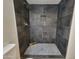 Walk-in shower with dark tile and pebble floor at 1633 N 62Nd Ave, Phoenix, AZ 85035