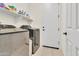 Well-equipped laundry room with stainless steel washer and dryer and storage shelves at 19724 W Palo Verde Dr, Litchfield Park, AZ 85340