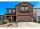 Two-story house with a brown exterior, two-car garage, and desert landscaping at 20673 N Marquez Dr, Maricopa, AZ 85138