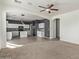 Open living room with neutral carpeting and a view into the kitchen at 20673 N Marquez Dr, Maricopa, AZ 85138