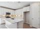 Modern kitchen with white cabinets, island, and stainless steel appliances at 21016 N 58Th Way, Phoenix, AZ 85054