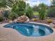 Inviting kidney shaped pool with a rock waterfall feature at 2164 W Muirfield Dr, Anthem, AZ 85086