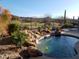 Refreshing pool with waterfall and desert landscaping at 2164 W Muirfield Dr, Anthem, AZ 85086