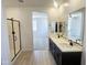 Bright bathroom with double sinks, large mirror, and a walk-in shower at 22311 W Monona Ln, Surprise, AZ 85387
