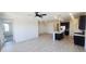 Open concept living area featuring tile flooring, a ceiling fan, and natural light at 22311 W Monona Ln, Surprise, AZ 85387