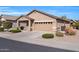 Tan one-story house with two-car garage and landscaping at 22424 W La Pasada Blvd, Buckeye, AZ 85326