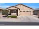 Tan one-story house with two-car garage, landscaping, and driveway at 22424 W La Pasada Blvd, Buckeye, AZ 85326