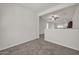 Open living area with neutral carpeting and a view into the kitchen at 22424 W La Pasada Blvd, Buckeye, AZ 85326