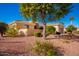 Tan colored house with a garage and mature trees at 22808 N Los Gatos Dr, Sun City West, AZ 85375