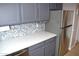 Modern kitchen with gray cabinets, white countertops, and hexagon backsplash at 2315 W Union Hills Dr # 112, Phoenix, AZ 85027