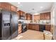 Modern kitchen with dark wood cabinets, stainless steel appliances, and tile flooring at 2613 E Bart St, Gilbert, AZ 85295