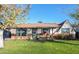 Charming single-story home with a well-maintained lawn and inviting front porch area with rocking chairs at 2649 N Granite Reef Rd, Scottsdale, AZ 85257