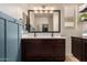 Modern bathroom with double sinks, a large mirror, and dark brown cabinets at 26538 N 132Nd Ln, Peoria, AZ 85383