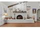 White brick fireplace with wood mantel and hearth at 2889 E Tremaine Ave, Gilbert, AZ 85234