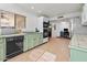 Bright kitchen features pale green cabinets, tile counters, and a view into adjacent sitting area at 2889 E Tremaine Ave, Gilbert, AZ 85234