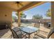 Covered patio with seating area, overlooking a sparkling pool and backyard at 30034 N 128Th Ave, Peoria, AZ 85383