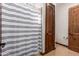 Bathroom with a striped shower curtain and wood door at 3630 W Bohl St, Laveen, AZ 85339