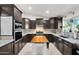 Modern kitchen with dark wood cabinets, granite counters, and stainless steel appliances at 3848 W Morrow Dr, Glendale, AZ 85308