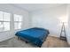 Spacious bedroom with blue bedding and large windows at 40465 W Chambers Dr, Maricopa, AZ 85138