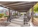 Community space featuring metal benches under a wooden pergola with townhomes in the background at 4058 E Erie E St # 103, Gilbert, AZ 85295