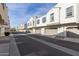 Row of townhomes featuring tan exteriors, blue shutters, garages, and a well-maintained street at 4058 E Erie E St # 103, Gilbert, AZ 85295