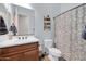 Clean bathroom with shower/tub combo, wood vanity, and patterned curtain at 4113 E Burnside Trl, Cave Creek, AZ 85331