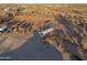 Aerial view of a large horse arena with a covered area and surrounding fencing at 49651 W Dune Shadow Rd, Maricopa, AZ 85139