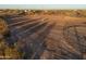 Aerial view of a large horse arena with a rectangular riding area and round pen at 49651 W Dune Shadow Rd, Maricopa, AZ 85139