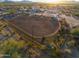 Aerial view of ranch property with arena, stables, and desert landscape at 49651 W Dune Shadow Rd, Maricopa, AZ 85139