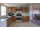 Modern kitchen with wood cabinets, gas range and stainless steel appliances at 49651 W Dune Shadow Rd, Maricopa, AZ 85139