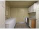 Functional laundry room with a large freezer and cabinets at 49651 W Dune Shadow Rd, Maricopa, AZ 85139