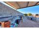 Outdoor kitchen with sink, counter, and seating area at 49651 W Dune Shadow Rd, Maricopa, AZ 85139