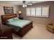 Main bedroom with a large bed and window with plantation shutters at 5215 W Acapulco W Ln, Glendale, AZ 85306