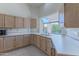 View of kitchen with light wood cabinets and a large window at 5335 W Bloomfield Rd, Glendale, AZ 85304