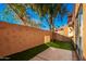 Landscaped backyard with artificial grass, a patio, and a tall wall at 5640 E Bell Rd # 1101, Scottsdale, AZ 85254