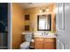 Powder room with wood vanity, toilet, and decorative wall accents at 5640 E Bell Rd # 1101, Scottsdale, AZ 85254