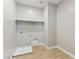 Bright laundry room with built-in shelving and tile floor at 5819 E Rose Garden Ln, Phoenix, AZ 85054