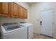 Laundry room with washer, dryer and upper cabinets at 6830 S Crystal Way, Chandler, AZ 85249