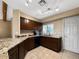 Kitchen with granite countertops, dark wood cabinets, and a tile floor at 9223 E Whitethorn Cir # 667, Scottsdale, AZ 85266