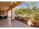 Relaxing covered patio with seating area, ceiling fan, and lush landscaping at 943 E Kortsen Rd # 10, Casa Grande, AZ 85122