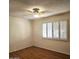 Well-lit bedroom featuring wood flooring and plantation shutters at 10216 W Ironwood Dr, Sun City, AZ 85351