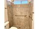 Walk-in shower with grab bars and tiled walls at 10216 W Ironwood Dr, Sun City, AZ 85351
