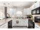 Modern kitchen with white cabinets and black appliances at 10339 N 58Th Ln, Glendale, AZ 85302