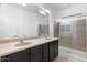 Bathroom with dual sinks, dark vanity and shower at 10808 W Cottontail Ln, Peoria, AZ 85383