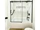 Updated bathroom with tub-shower featuring black framed glass doors and contrasting hardware at 10846 E Navajo Dr, Sun Lakes, AZ 85248
