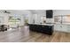 Modern kitchen featuring an island with seating, white cabinets, and stainless steel appliances at 10846 E Navajo Dr, Sun Lakes, AZ 85248