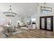 Bright living room with vaulted ceiling, fireplace, and modern chandelier above dining table at 10846 E Navajo Dr, Sun Lakes, AZ 85248